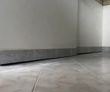 Sunken concrete floor inside a home, dipping towards the centre of the room