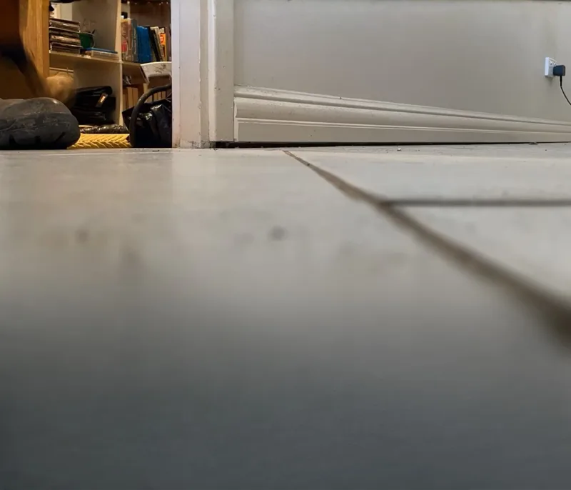 Interior concrete floor slab showing visible slope toward one corner of the room