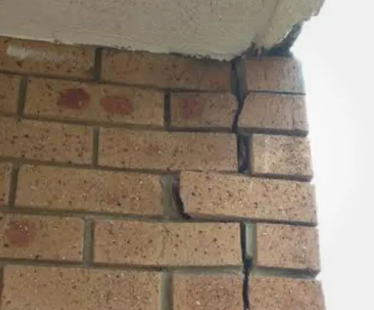 Vertical crack at brick wall corner with soffit separation caused by lateral expansion