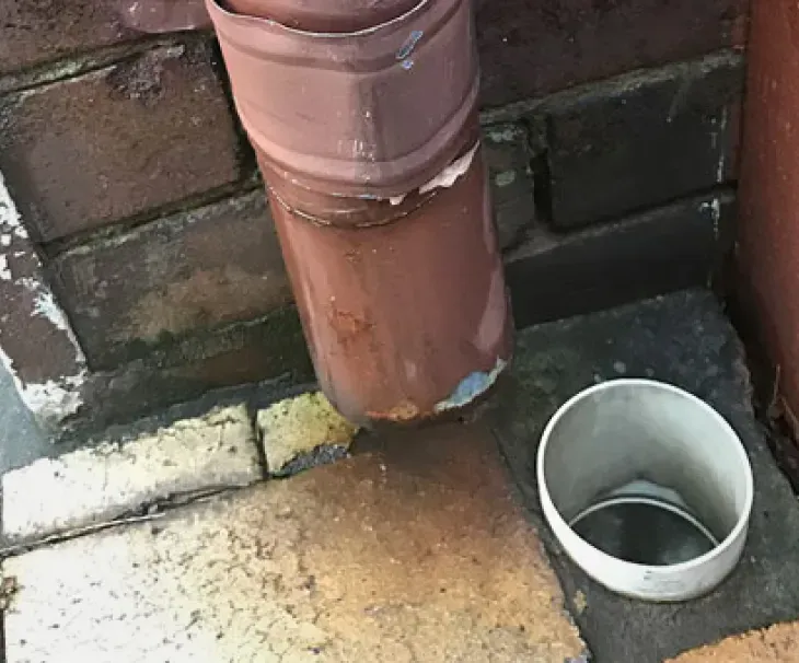 Misaligned drainpipe allowing water to pool near house foundations