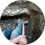 A builder digging foundation holes for mass concrete underpinning