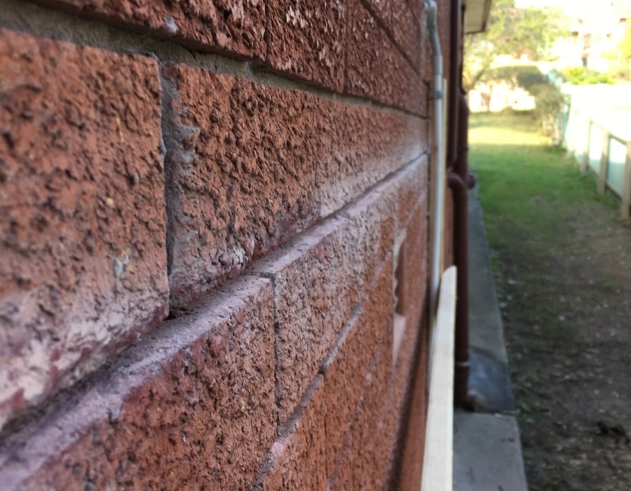 Close-up of solid brick wall foundation repair preventing subsidence risk.