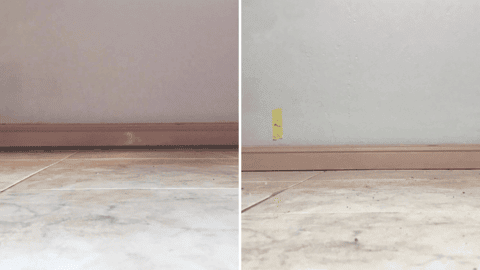 Tiled floor with wall stain and yellow tape indicating rising damp repair.