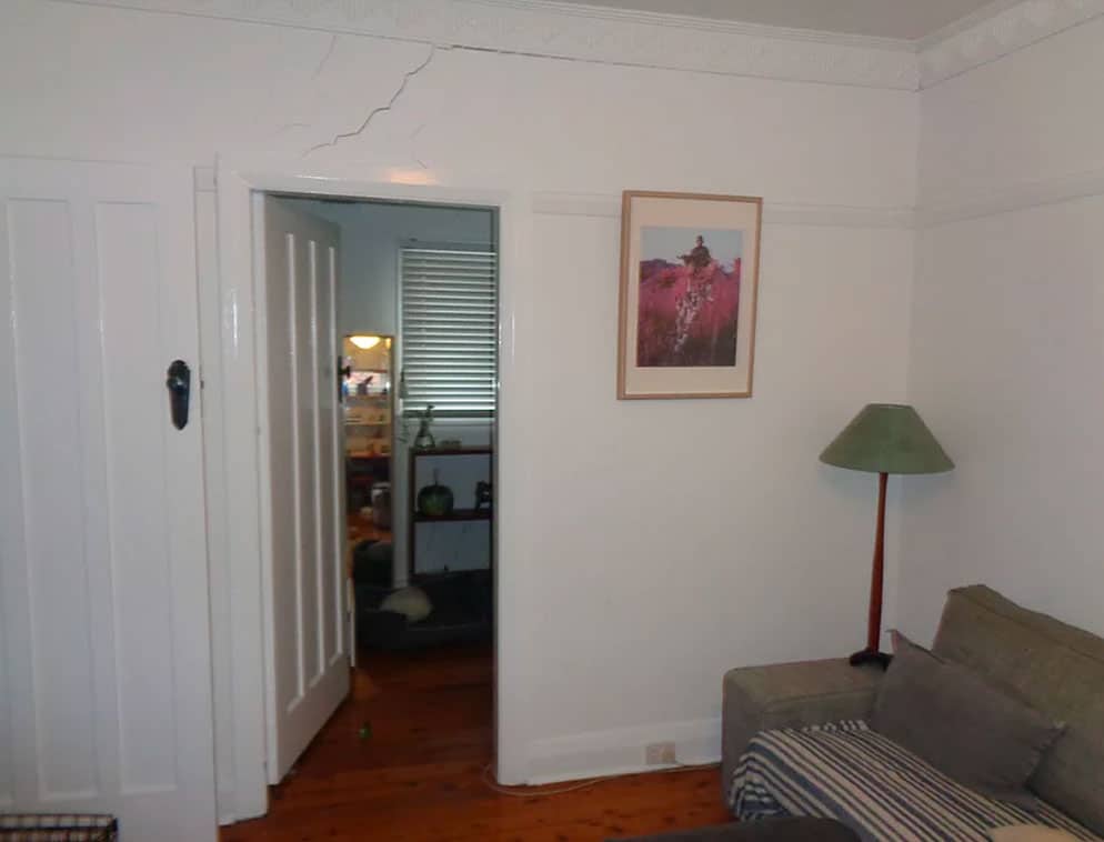 Cracked wall above door frame indicating potential foundation subsidence repair needed.