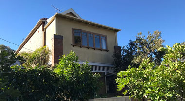 Two-storey house with wall cracks indicating subsidence and foundation repair needs.