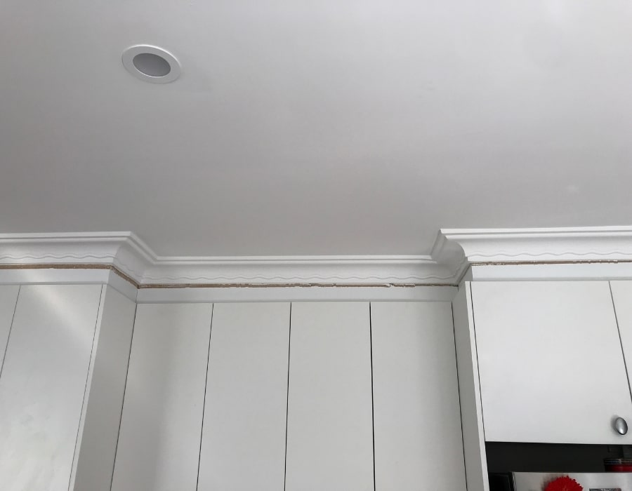 Ceiling crack along crown moulding indicates possible subsidence and foundation repair needs.