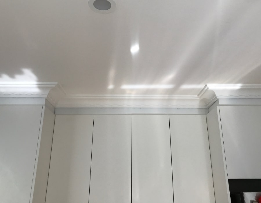 Sunlit kitchen ceiling with wall cracks indicating subsidence and foundation repair needs.