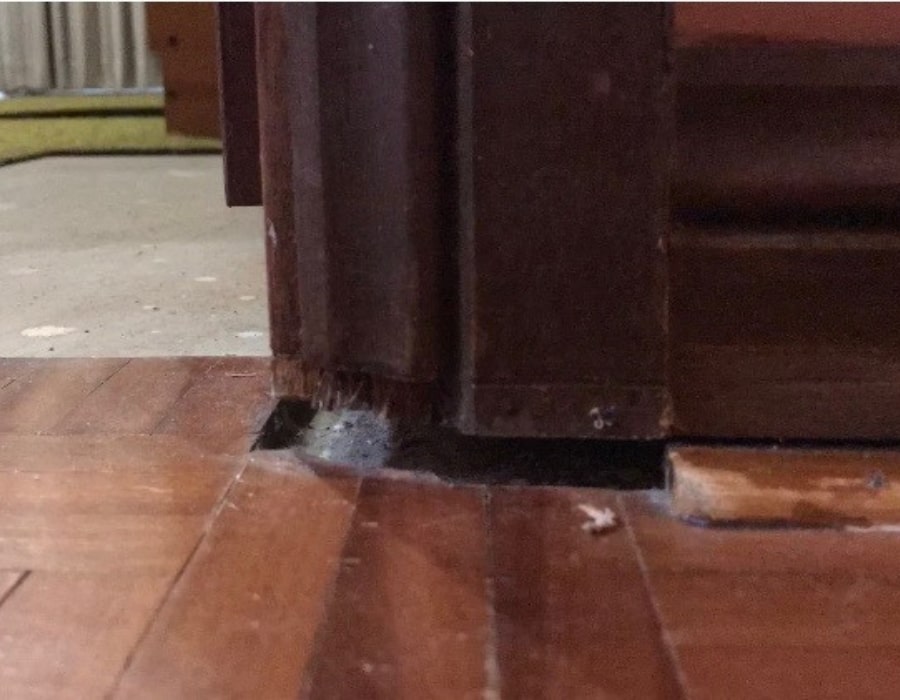Uneven floor gaps at door frame indicate subsidence and foundation repair needs.