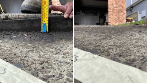 Concrete curb height measured for subsidence assessment and foundation repair solution Close-up of concrete curb showing signs of rising damp inspection.