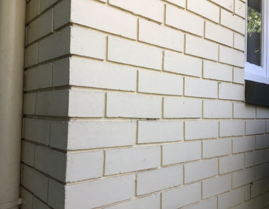 Light brick corner wall with stable foundation repair using GeoPoly technology.