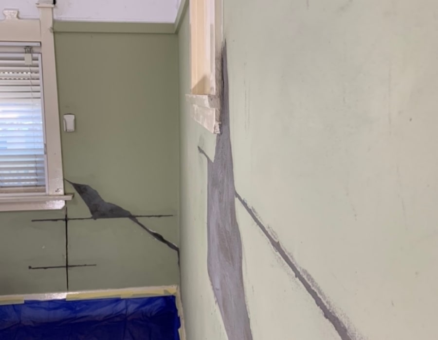 Foundation repair addressing wall cracks and rising damp with grey filler.