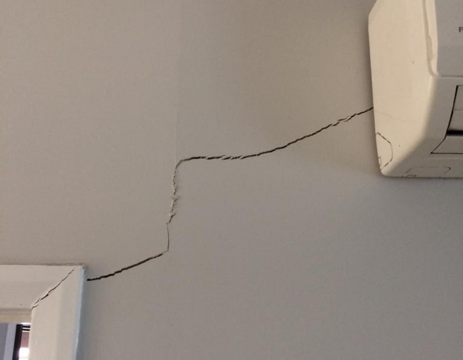 Jagged wall crack above door indicating possible subsidence and foundation repair need.