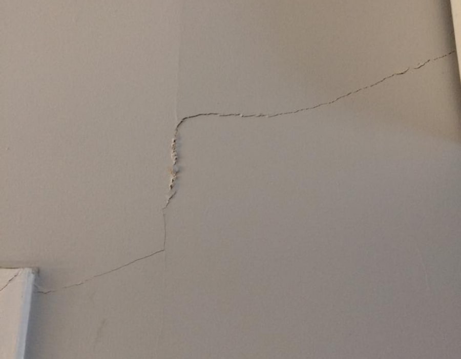 Diagonal wall crack indicating subsidence and foundation movement requiring structural repair.