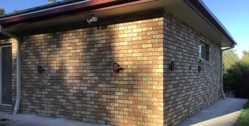 Granny flat light brown brick wall showing wall cracks and rising damp issues.