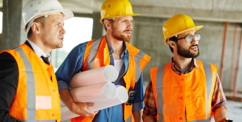 A builder, engineer and surveyor reviewing a building site