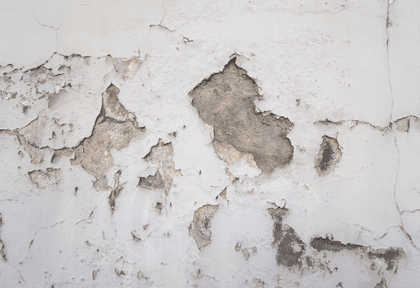Peeling white paint with wall cracks indicating rising damp and subsidence issues.