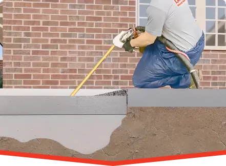 Worker performs foundation repair injecting GeoPoly beneath concrete slab for subsidence correction.