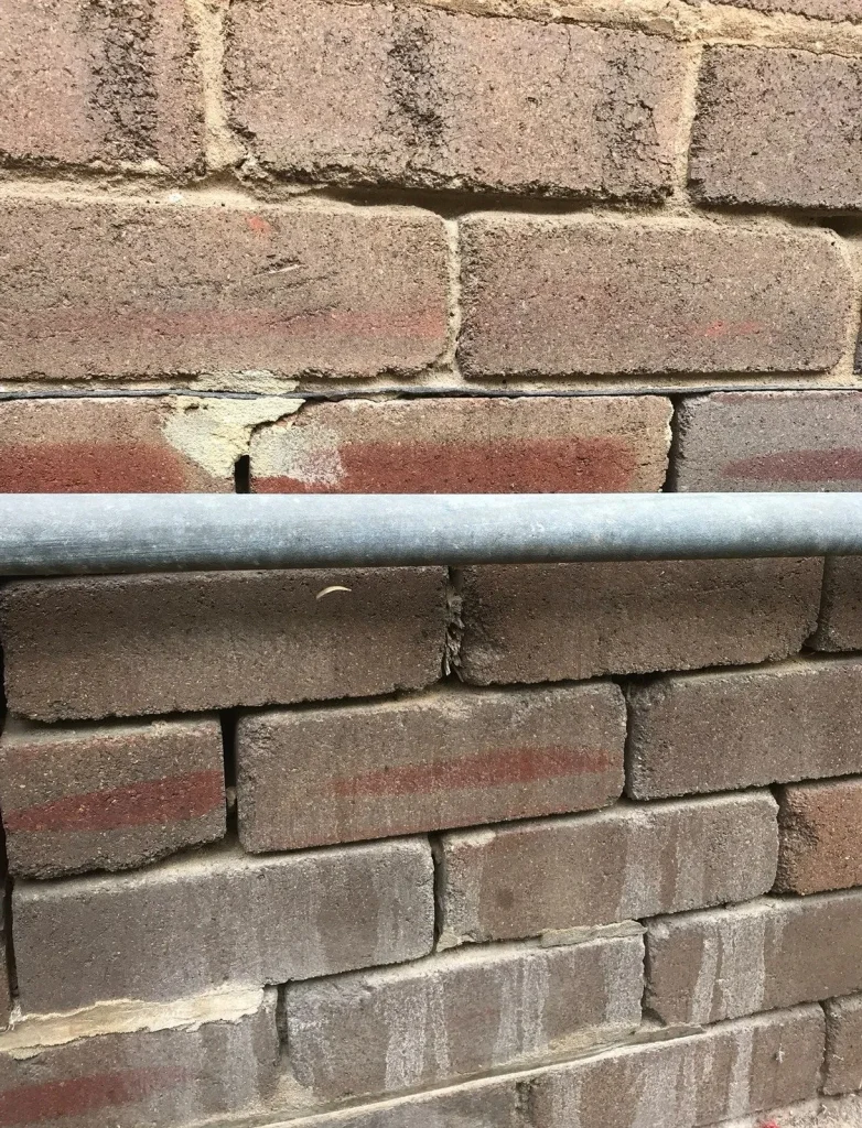 Crumbling mortar caused by damp proof course failure.