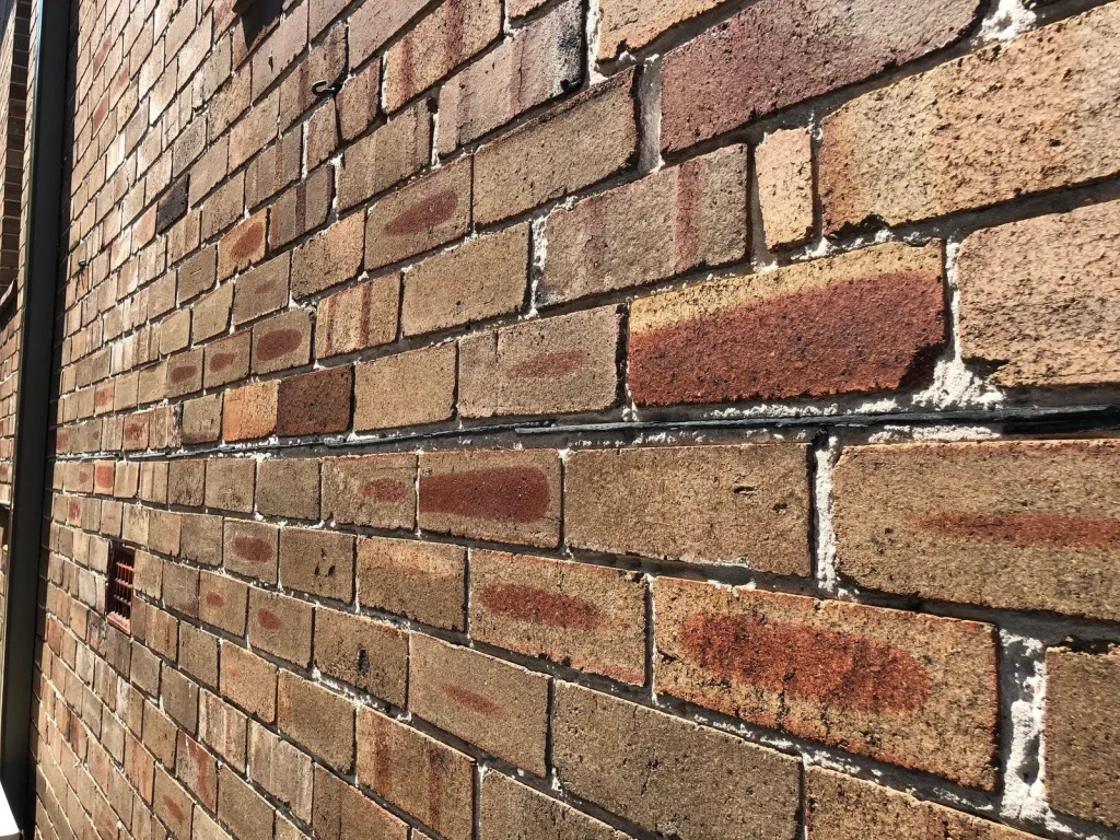 Damp proof course installation in a masonry wall.